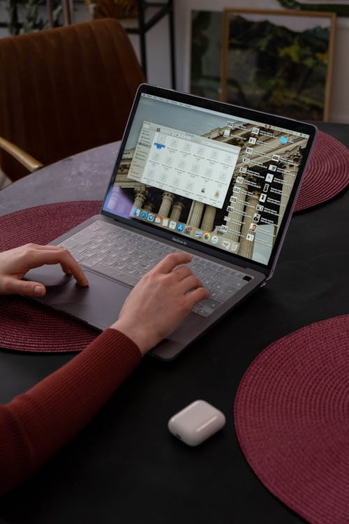 Close-up of hands typing on a laptop in a cozy workspace, depicting modern authentic content creation and blogging