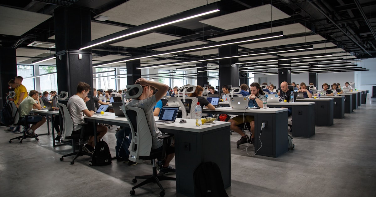 Modern workspace with multiple screens, forward-looking content strategy requires continuous optimization and freshness updates